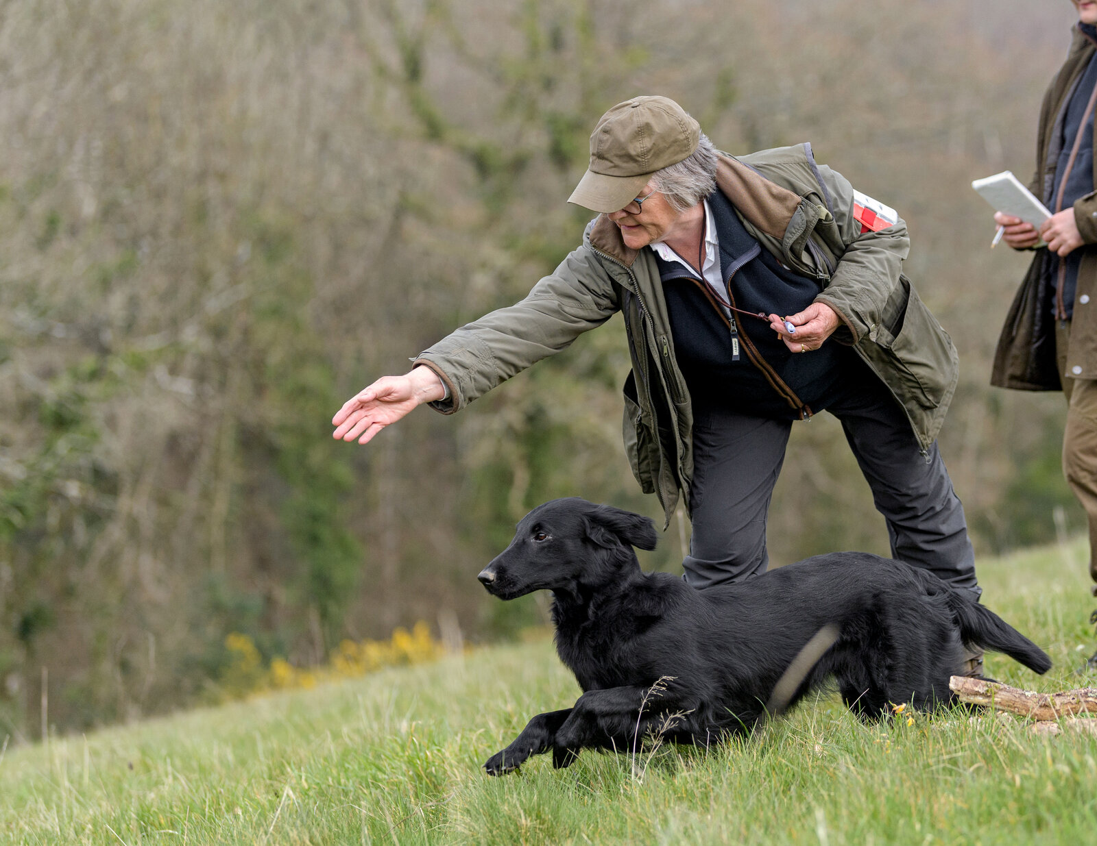 Handlers with retrieved pheasants and dogs beside a lake